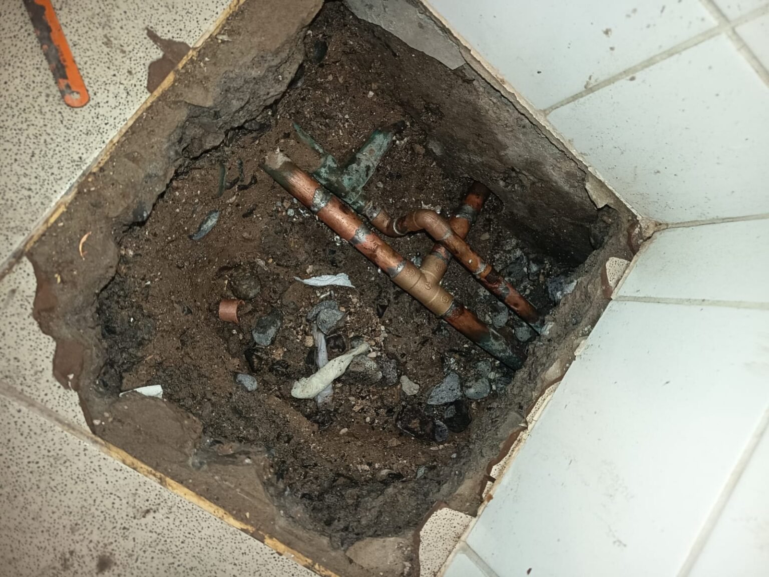 Suelo abierto para reparar una fuga en tubería de cobre