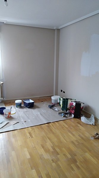 Salón en proceso de pintura con protecciones en el suelo